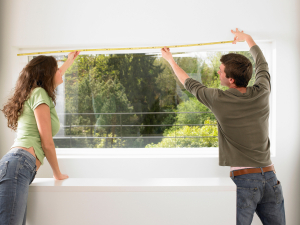 Couple taking measurement of their window 
